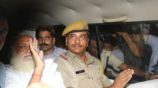 ২০১৩ সালে ১৬ বছরের মেয়েকে ধর্ষণের অভিযোগে আটক হবার পর ধর্মগুরু আসারাম বাপুকে পুলিশ নিয়ে যাচ্ছে।