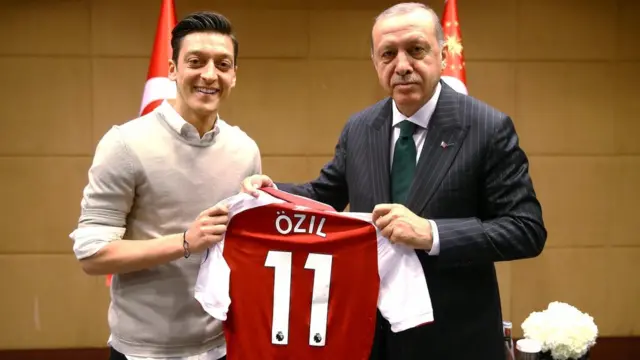 Mesut Ozil handsTurkish president Recep Tayyip Erdogan a signed shirt