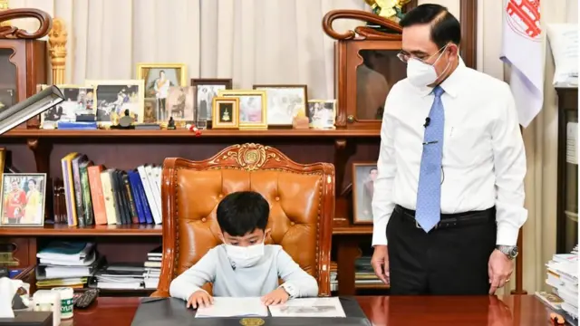 พล.อ. ประยุทธ์ จันทร์โอชา ถ่ายภาพกับเด็กน้อยขณะนั่งเก้าอี้นายกฯ ภายในตึกไทยคู่ฟ้า ทำเนียบรัฐบาล