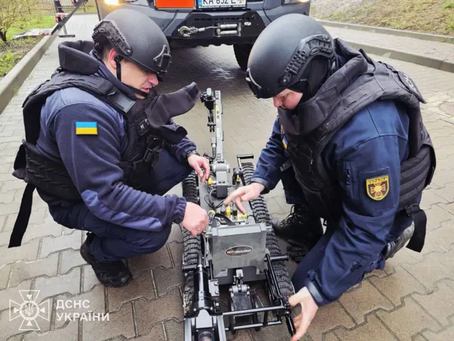 Двоє працівників ДСНС біля робота