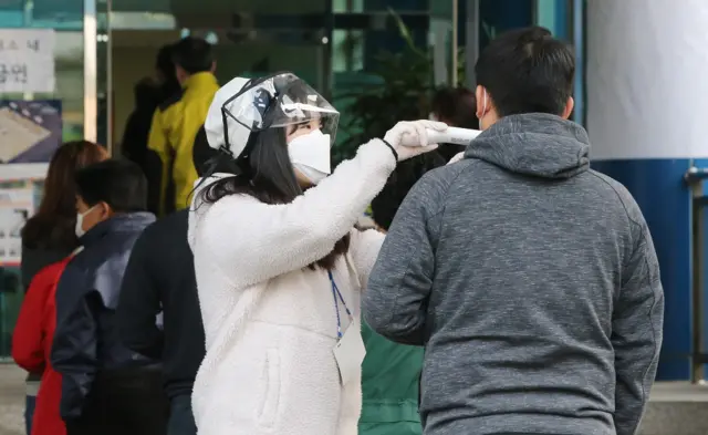 15일 오전 대전 동구 대전동서초등학교에 설치된 삼성동 제3투표소에서 선거관계자들이 발열검사를 하고 있다