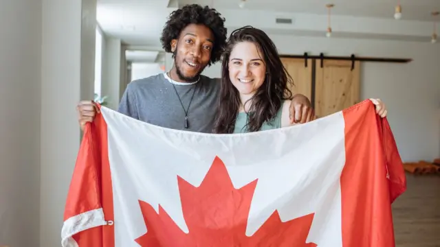 Duas pessoas com uma bandeira do Canadá