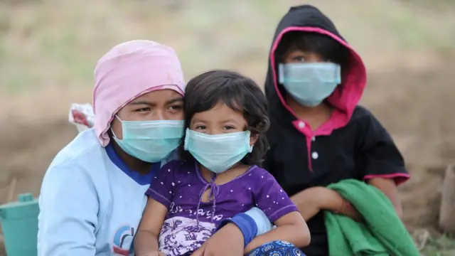 اندونيسيون يرتدون كمامات