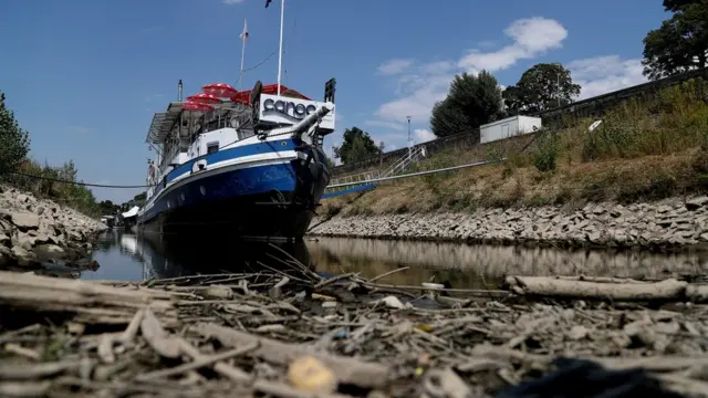A restaurant ship lies in a dried-out river bed of the Rhine river in Duesseldorf, Germany, 26 July 2018.