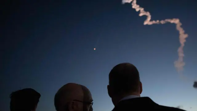 Люди смотрят на след корабля