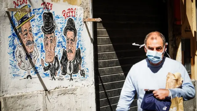 A person wearing a protective face mask walks at Quartieri Spagnoli, Naples, Italy, 18 March 2020
