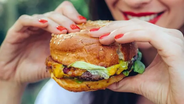 Mulher comendo hamburguer