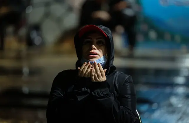 An Iranian woman takes part in ritual prayers in the rain for Laylat al-Qadr (Night of Destiny), one of the holiest nights during the Muslim fasting month of Ramadan, outside the Imamzadeh Ainali-Zeinali mosque in the capital Tehran, on May 1, 2021. (Photo by ATTA KENARE / AFP) (Photo by ATTA KENARE/AFP via Getty Images)