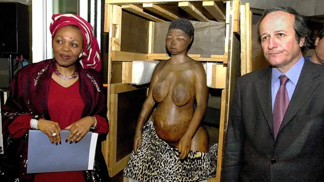 Ambasaderi wa South Africa muri France Thuthukile Edy Skweyiya, ibumoso, na Roger-Gérard Schwartzenberg, Minisitiri w'ubushakashatsi w'Ubufaransa, bari iruhande rw'ikibumbano cyakozwe ku mubiri wa Baartman mu muhango wo kwemeza gusubiza ibisigazwa bya Baartman iwabo, mu 2002.