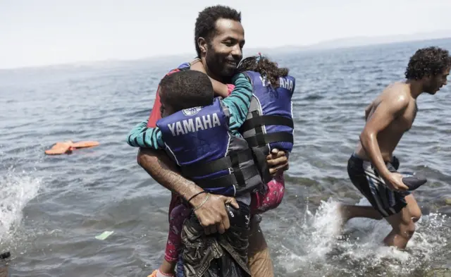 Türkiye üzerinden Yunanistan'a ulaşmayı başaran bir sığınmacı, karaya varmanın mutluluğunu yaşıyor