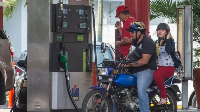 Pareja en estación de gasolina.