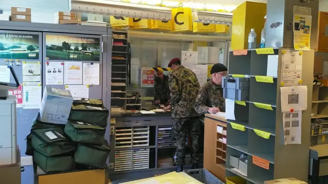 Swiss army post officers sorting parcels