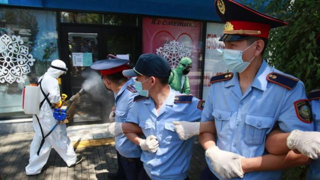 Полицейские и люди в защитных костюмах с аппаратами для дезинфекции 6 июня