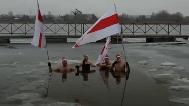 야권을 상징하는 3색기를 들고 얼음물에 몸을 담근 사람들