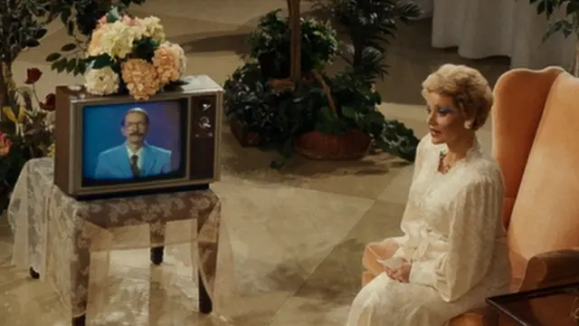 Cena do filme 'Os Olhos de Tammy Faye', em que Tammy (interpretada por Jessica Chastain) entrevista Steve (Randy Havens)