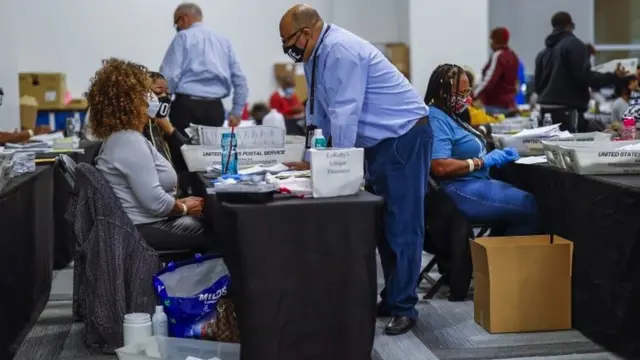 Vote counters round a desk
