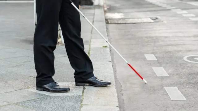 सड़क पार करता नेत्रहीन व्यक्ति