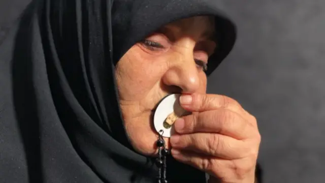 Yusra Al Amin kissing a pendant