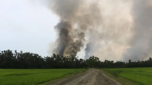 रखाइन में एक गांव से उठता धुंआ