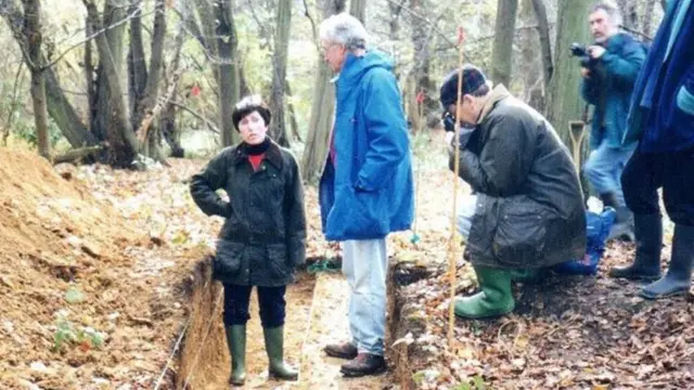 A professora Patricia Wiltshire entre quatro homens fotografando no meio da floresta