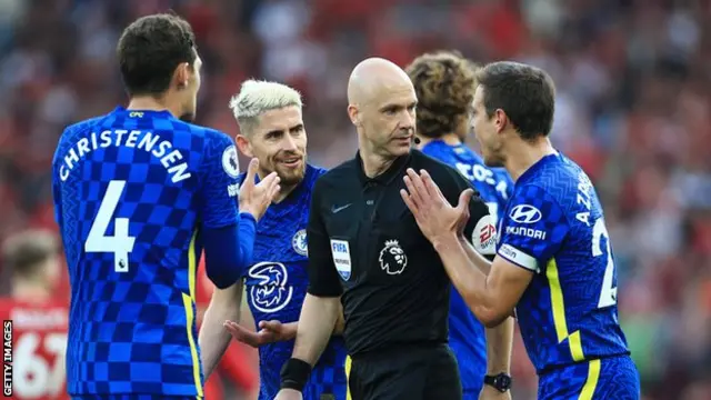 Chelsea players surround referee Anthony Taylor