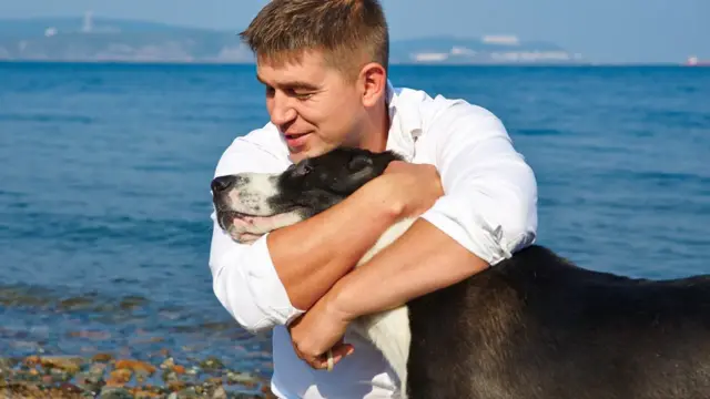 Homem abraçado a cão