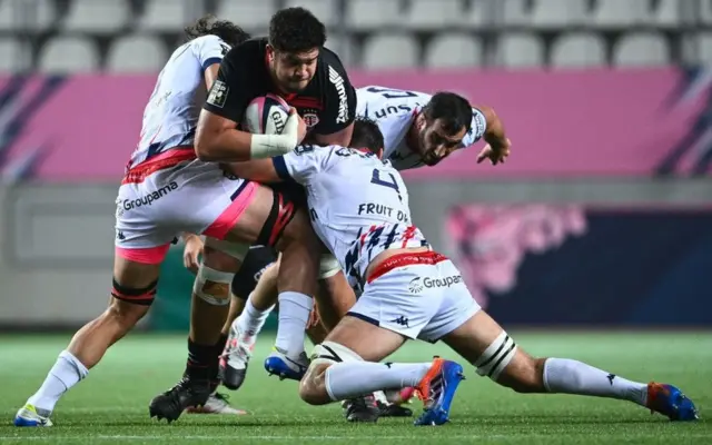 Umunye Australiya akinira Toulouse yahuje ubwayi na Meafou (hagati) arwanira umupira mu gihe umunye Afrika y'epfo wa Stade Francais yahuje na Gerbrandt Grobler (ibubamfu) mu rukino rwa rugby rwo mw'ihiganwa French Top 14 hagati ya Stade Francais na Toulouse ku kibuga ca Jean-Bouin i Paris itariki 1 z'ukwa cumi na rimwe 2020.