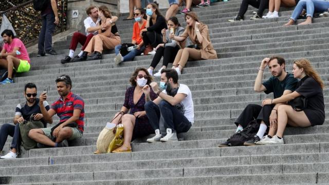 People sit outside the Sacre-Couer in Paris