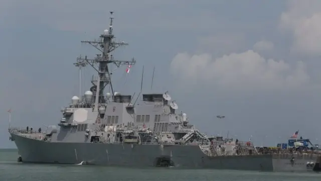 USS John S McCain bị hư hại sau khi va chạm và hiện đang đậu tại căn cứ quân sự Changi ở Singapore. Ảnh do Hạm đội Bảy của Hoa Kỳ cung cấp.