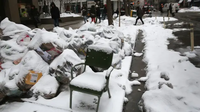 Una silla en medio de una acera llena de nieve en Nueva York