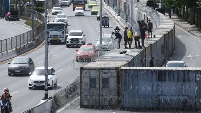 กำแพงตู้คอนเทนเนอร์และรั้วลวดหนามด้านหน้ากรมทหารราบที่ 1