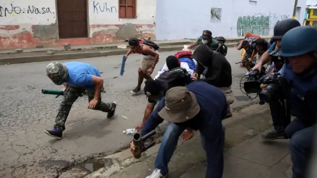 Grupo de manifestantes portando armas caseras.