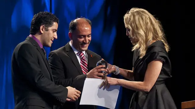 آرش (وسط) و کامیار علایی (چپ) جایزه الیزابت تیلور را از شارون استون میگیرند