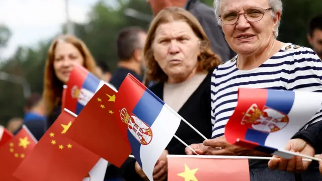 People waving Chinese and Serbian flags gather outside the Palace of Serbia during a welcome ceremony for Chinese President Xi Jinping in Belgrade, on May 8, 2024. Chinese President Xi Jinping will hold talks with his Serbian counterpart in Belgrade on May 8, 2024, as Beijing seeks to deepen its political and economic ties with friendlier countries in Europe