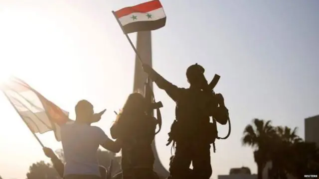 दमास्कसमध्ये सीरियाचा झेंडा फडवताना नागरिक