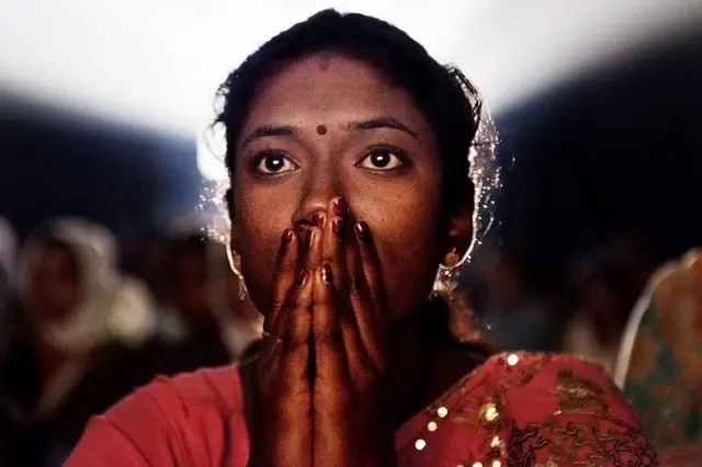 ટ્રાવેલિંગ સિનેમા નિહાળતા મહિલાનો ફોટો