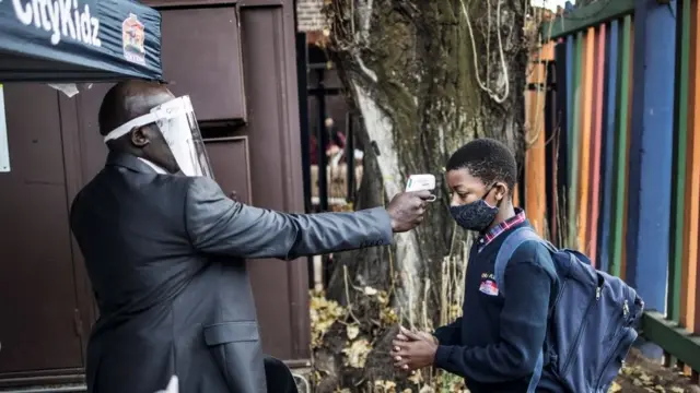 Un enfant de Johannesburg fait mesurer sa température lorsqu'il entre dans les locaux de l'école le 1er juin 2020.