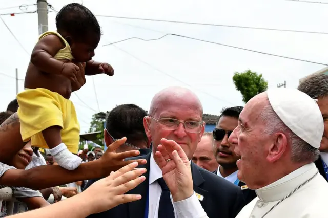 Papa'nın Cartagena ziyareti sırasında kalabalıklardan birisi, bebeğini kutsaması için Papa'ya uzatıyor.