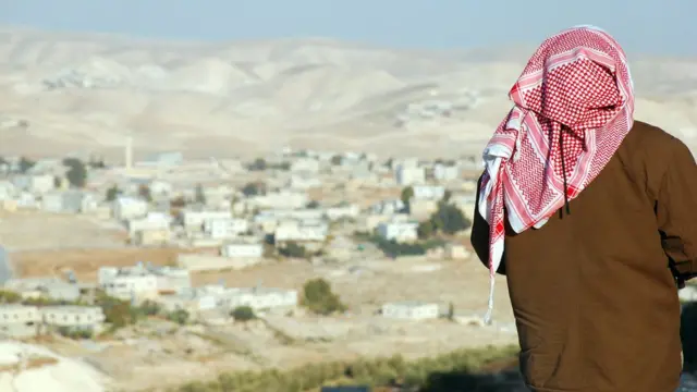 Palestino de costas olha sua vila
