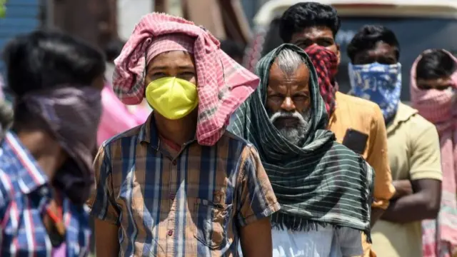 சென்னையில் உணவுப் பொட்டலங்களை பெறுவதற்காக வரிசையில் நிற்கும் குடியேற்ற தொழிலாளர்கள்.