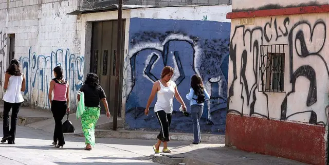 Mujeres en la calle, entre murales de la MS-13