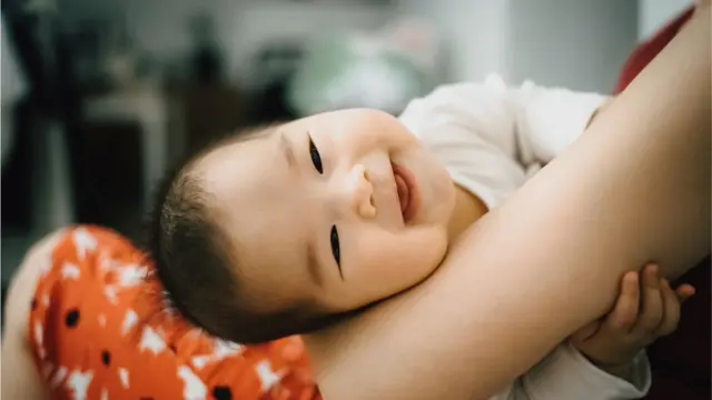 తల్లి చేతుల్లో నవ్వుతున్న బేబీ