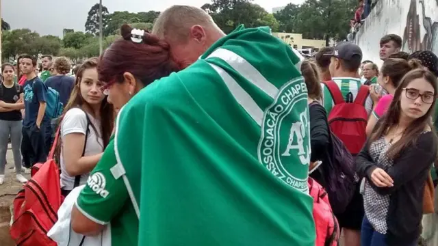 Trcedor com bandeira abracado a mulher e chorando