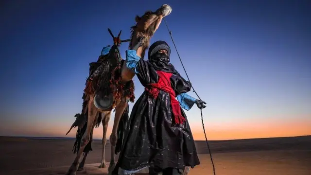 صورة لرجل مع جمله وعلى الجمل زينة