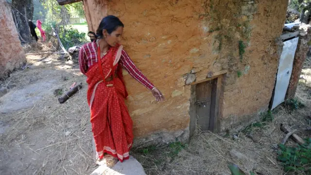 Mujer frente a una cabaña