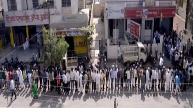 बैंक के बाहर खड़ी लंबी कतार