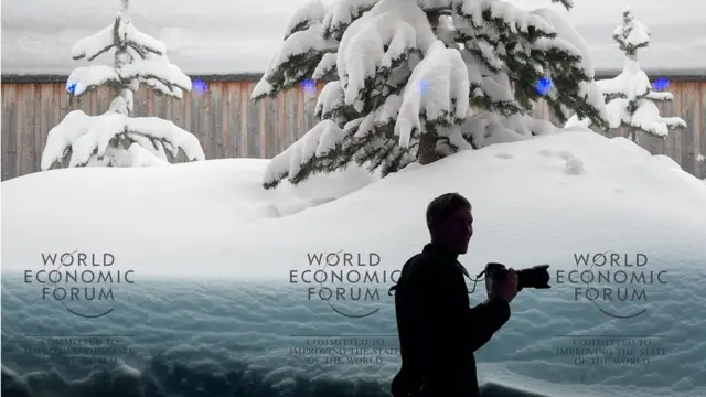 一名摄影师站在达沃斯论坛的一间会议室中