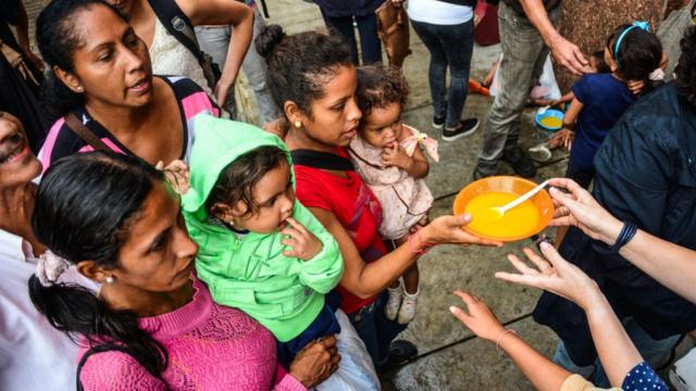 Personas recibiendo comida en Caracas