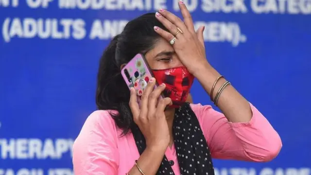 A woman on the phone outside a hospital