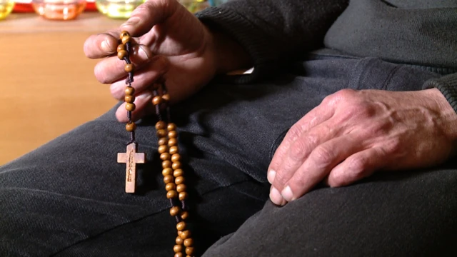 رجل يحمل مسبحة وبها صليب